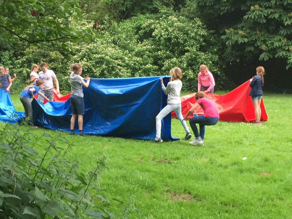 Twee fanatieke teams in een race door de kruiptunnel van de tienkamp Bij Klimpark Streekbos. Een van onze groepsactiviteiten bij Klimpark Streekbos.