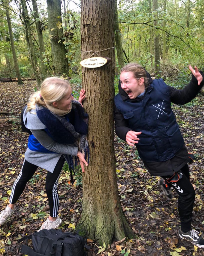 Meiden beelden letters uit tijdens uitdagend spel The Hunger Games van Klimpark Streekbos. Een van de groepsactiviteiten bij Klimpark Streekbos.